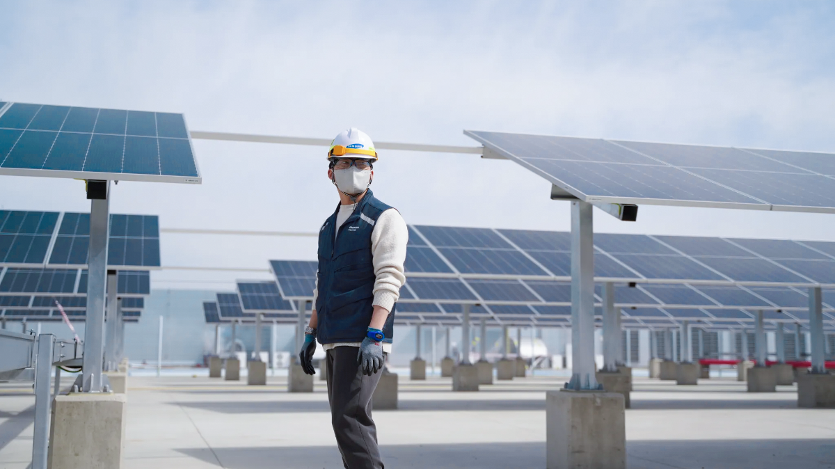 A safety and environment team employee wearing a safety helmet at a solar power facility.