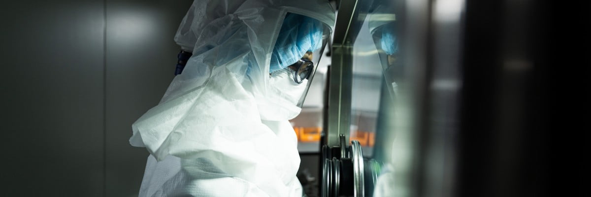 Researcher operating equipment in cleanroom