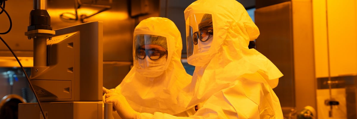 Researchers working under yellow lighting