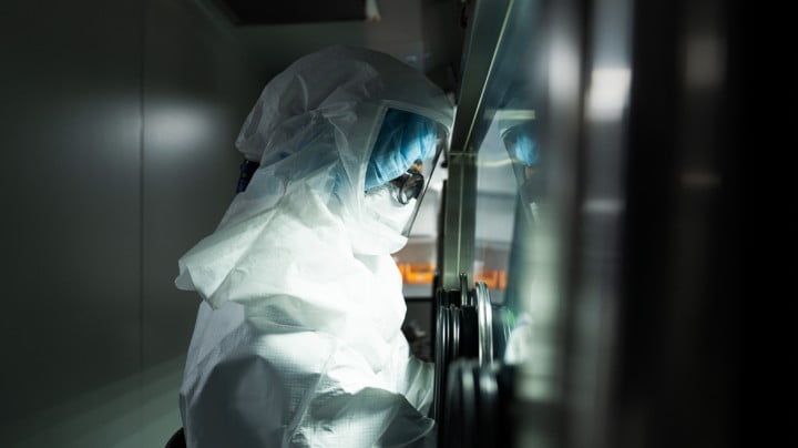 Researcher operating equipment in cleanroom