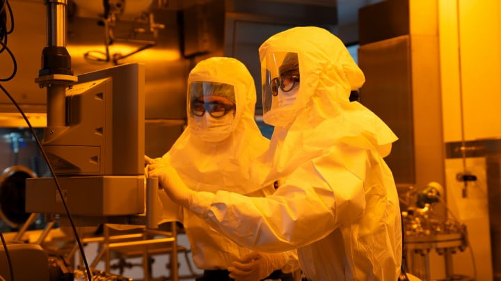 Researchers working under yellow lighting